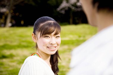 Daytime portrait of japanese couple walking at cherry garden