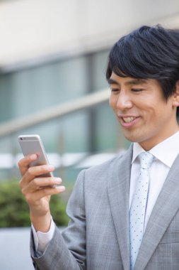 Akıllı telefon kullanarak Asyalı işadamını kapatın.