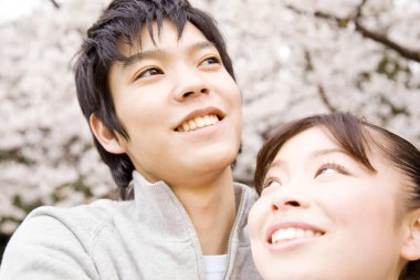 Parkta genç bir çift sarılıyor. 