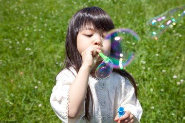 Asyalı kız sabun köpüğü üflüyor