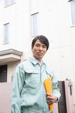 Dosyasıyla birlikte üniformalı genç Asyalı tamirci