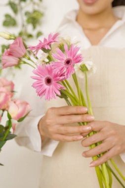 Elinde güzel pembe çiçek buketi tutan kadın, yakın plan.