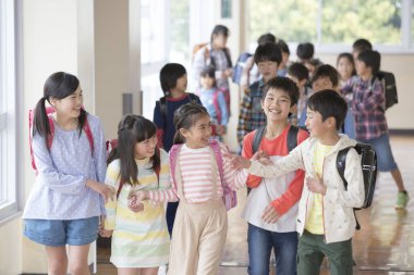 Ders arası koridorda yürüyen Asyalı öğrenciler. 