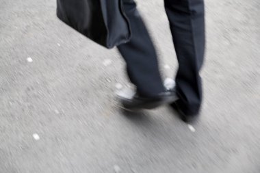 İş adamı şehir yolunda yürüyor.