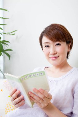 Genç bir kadın kitap okuyor.