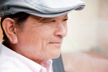 Şapkalı bir Asyalı 'nın açık hava portresi.