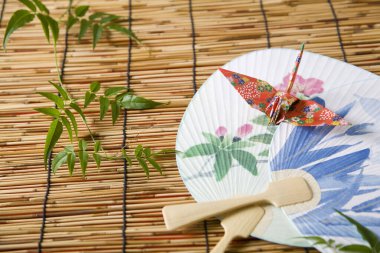 Bambu bir paspasın üzerindeki dekoratif yelpazelerin yakın çekimi.