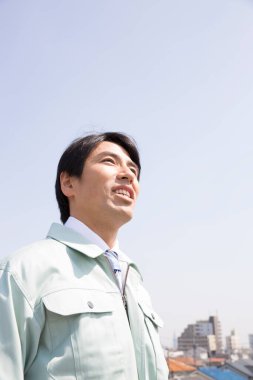 Mavi gökyüzüne karşı kendinden emin Japon işadamının portresi