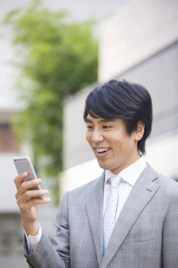 Akıllı telefon kullanarak Asyalı işadamını kapatın.