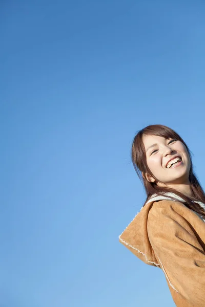 portrait of beautiful Japanese woman against blue sky background