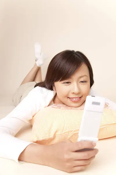 Усміхнена Азіатська Жінка Допомогою Мобільного Телефону Лежить Ліжку Подушкою — стокове фото