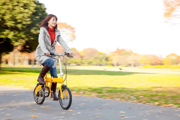 秋の公園で自転車を持っている若いアジアの女性 — ストック写真