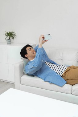 Genç adam akıllı telefon kullanıyor.