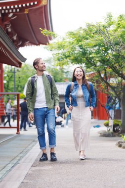 Beyaz adam ve Japon kadın Japon tapınağını geziyorlar.