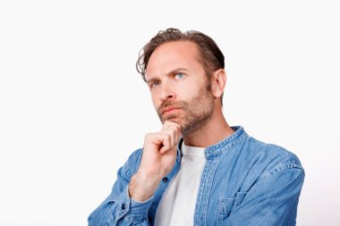 Beyaz arka planda poz veren mavi kot gömlekli beyaz adamın stüdyo portresi.