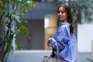 Şehir caddesinde yürüyen güzel Asyalı kadının portresi.