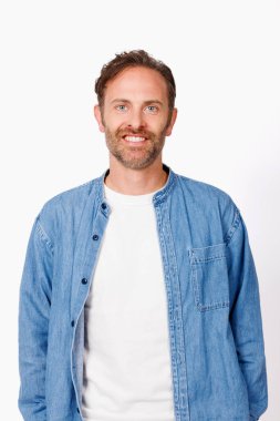 Beyaz arka planda poz veren mavi kot gömlekli beyaz adamın stüdyo portresi.