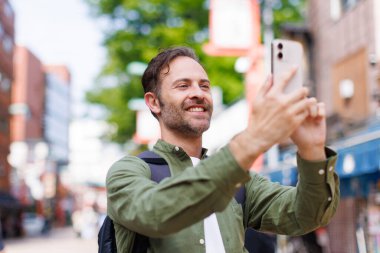 Kafkas adam cep telefonuyla antik Japon tapınağında fotoğraf çekiyor.