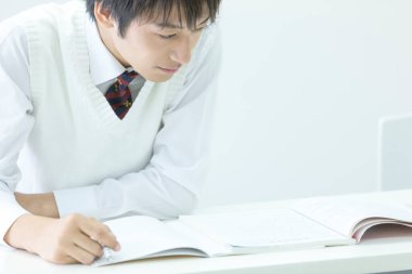 Genç Asyalı bir öğrenci kitap okuyor. 