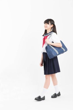 Beyaz arka planda okul üniformalı güzel genç bir öğrencinin portresi.