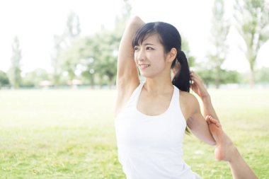 Güzel Japon kadın parkta yoga yapıyor.