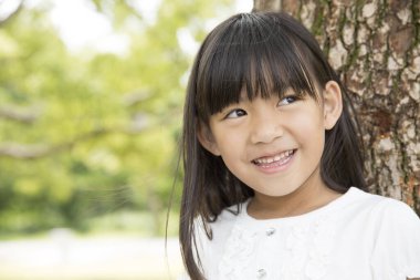 Yaz parkında yürüyen tatlı bir Japon kızı, açık havada eğlenen komik bir çocuğun gündüz portresi.