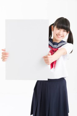 Okul üniformalı güzel bir öğrencinin portresi. Elinde beyaz bir tahta var.