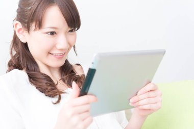 Asyalı kadın evde tablet kullanma