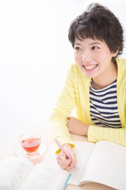 Genç bir kadın deftere bir şeyler yazıyor.