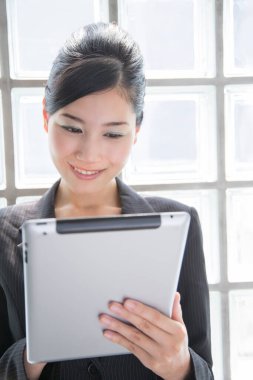 Ofisteki dijital masayı kullanan Asyalı genç iş kadınının stüdyo portresi