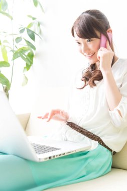 Bilgisayarı kullanırken Asyalı kadının telefonunu kapat.