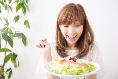 Elinde bir tabak salata tutan bir kadın. 