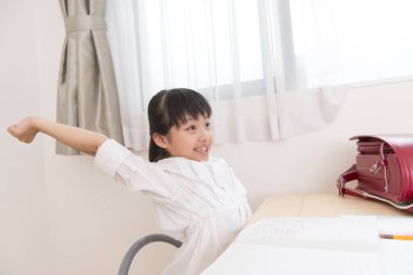 Küçük Asyalı kız ödevini yapıyor. 