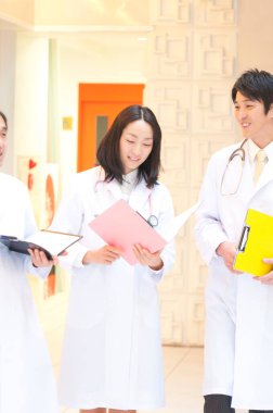 Doktor ekibi hastanede bekliyor. İki erkek ve bir kadın iş başında. 