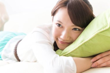 Yatakta yatan Asyalı genç bir kadının portresi. 