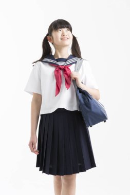 Beyaz arka planda okul üniformalı güzel genç bir öğrencinin portresi.