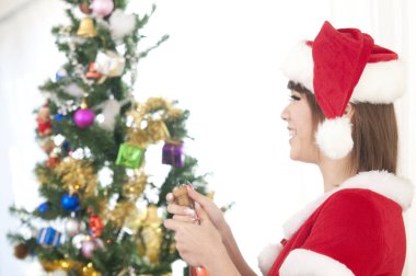 Noel ağacının yanında şampanya şişesi açan kız. 