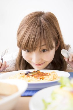 Evde spagettisi olan güzel bir Japon kadın.