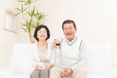 Kanepede oturan Asyalı çift.