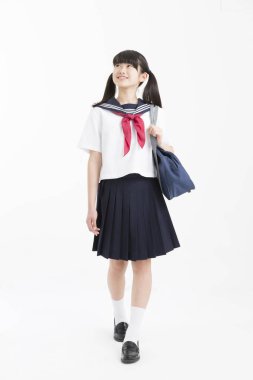 Beyaz arka planda okul üniformalı güzel genç bir öğrencinin portresi.