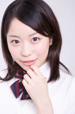 Stüdyoda üniformalı gülümseyen Japon öğrenci portresi.