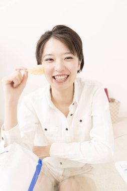 Cheeps yiyen genç Asyalı kadın 