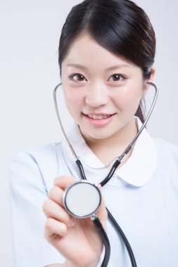 Beyaz üniformalı güzel Asyalı doktorun portresi.