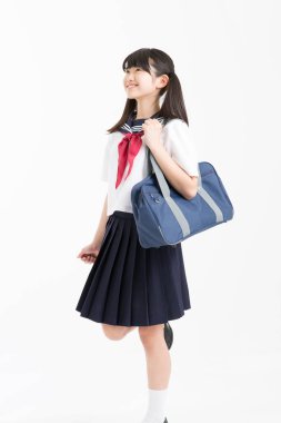 Beyaz arka planda okul üniformalı güzel genç bir öğrencinin portresi.