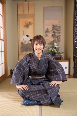 Etnik kaplıca otelinde geleneksel yukata giymiş yakışıklı Japon gencin portresi.