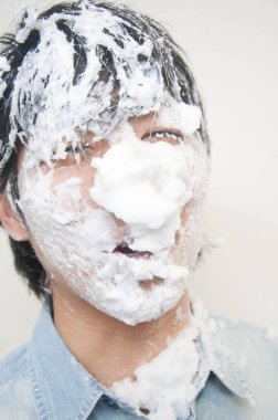 Yüzünde beyaz köpük olan Asyalı bir adam.