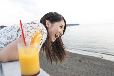 Plajda portakal suyu içen kadın. 