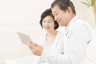 Tablet bilgisayar kullanan Asyalı yaşlı çift