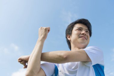  Parkta gerinen Asyalı adam.