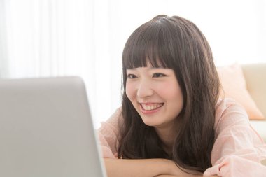 Dizüstü bilgisayarda çalışan genç Asyalı kadın